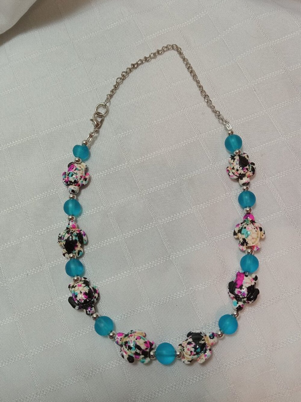 Pretty handmade necklace with little turtles and glass bead